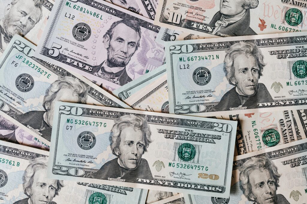 pexels-photo-4386442-4386442 Top view of different types and colors American dollars placed together on each other