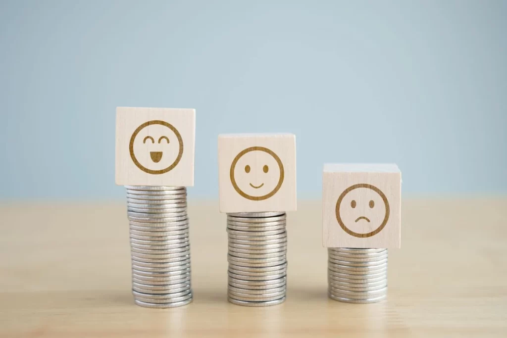 Stacks of coins with happy, neutral, and sad faces representing different paid survey payouts