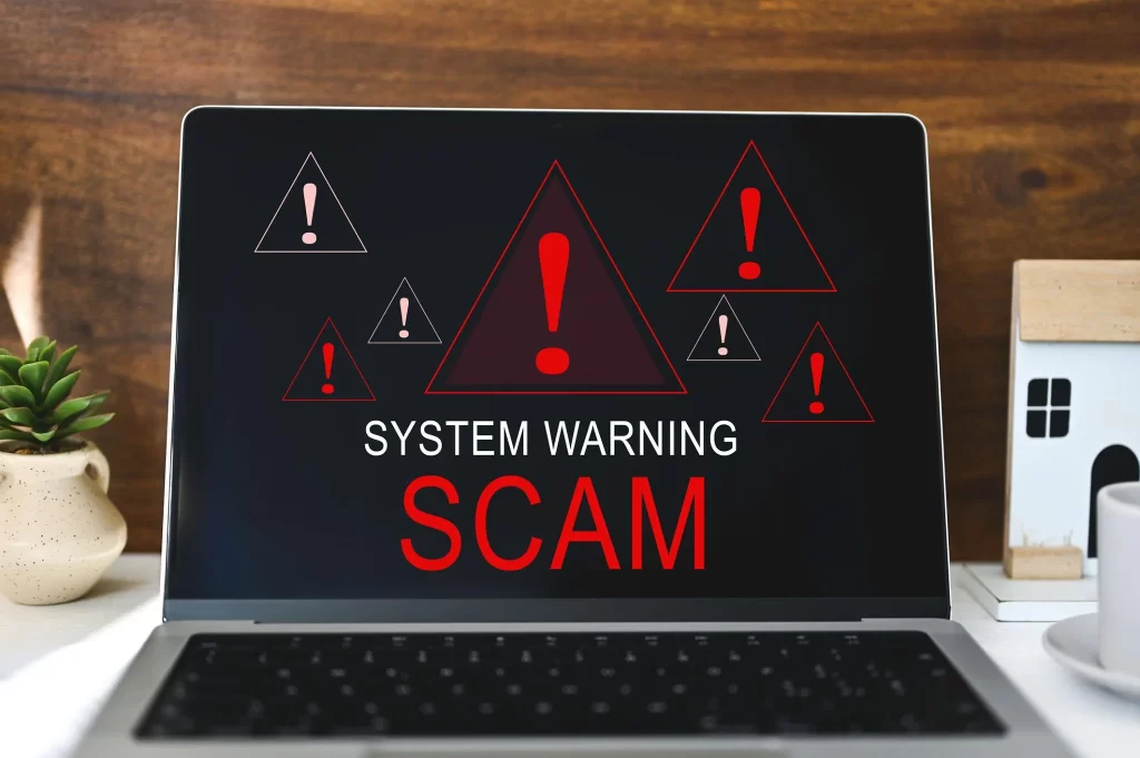 Laptop screen displaying system warning scam alert with red security icons representing paid survey fraud and fake platform risks